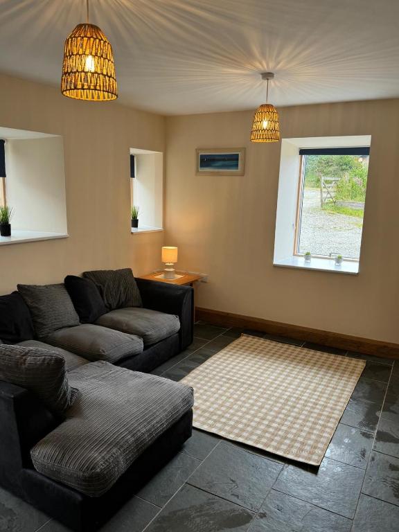 a living room with a couch and a window at Dovecot in Altarnun