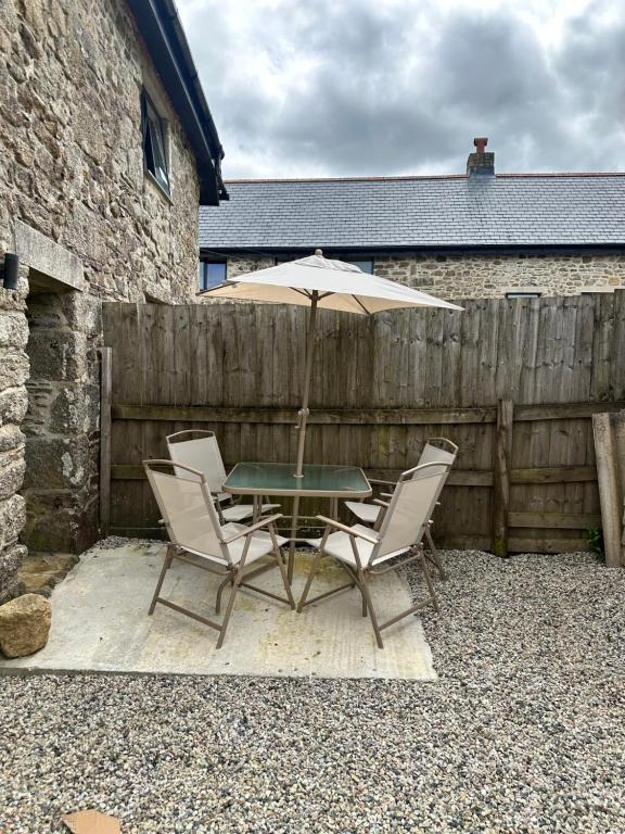 a table and chairs with an umbrella on a patio at Dovecot in Altarnun