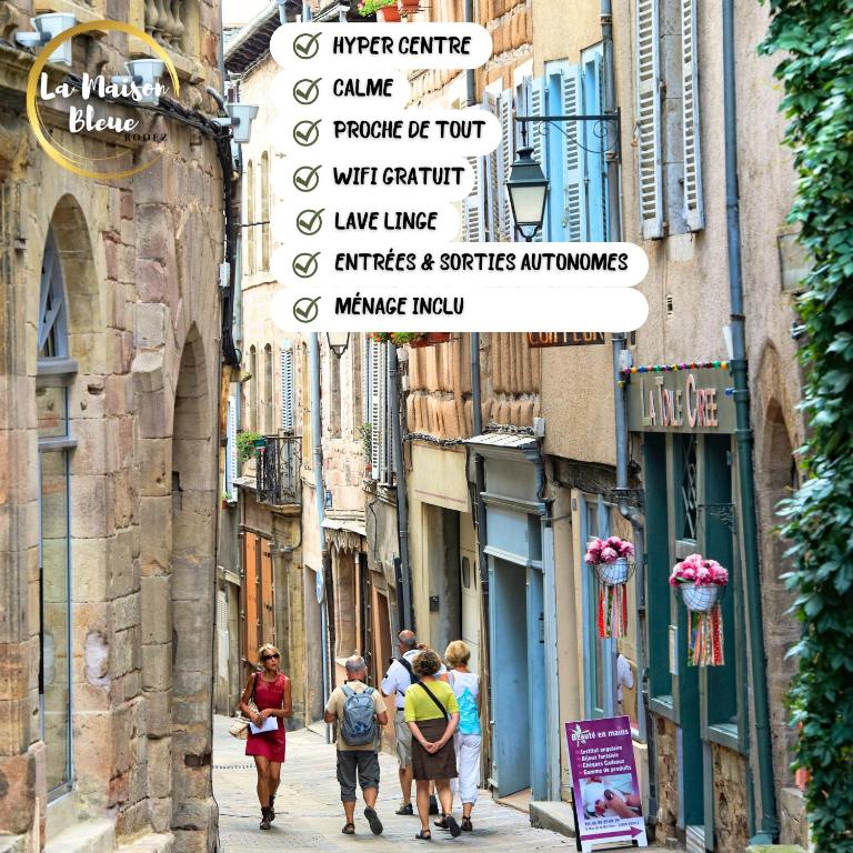 Un groupe de personnes marchant dans une rue étroite dans l'établissement La Maison bleue, un emplacement de choix à Rodez, à Rodez