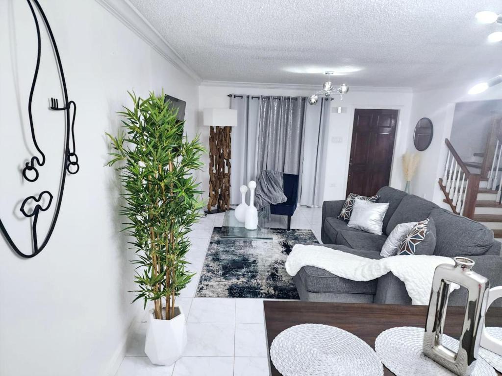 un salon avec un canapé et une table dans l'établissement Tropical Luxe Modern Townhouse, à Montego Bay