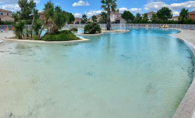 - une grande piscine d'eau bleue dans un complexe dans l'établissement Maison Vacances au Domaine de Golf Piscine, à Fabrègues