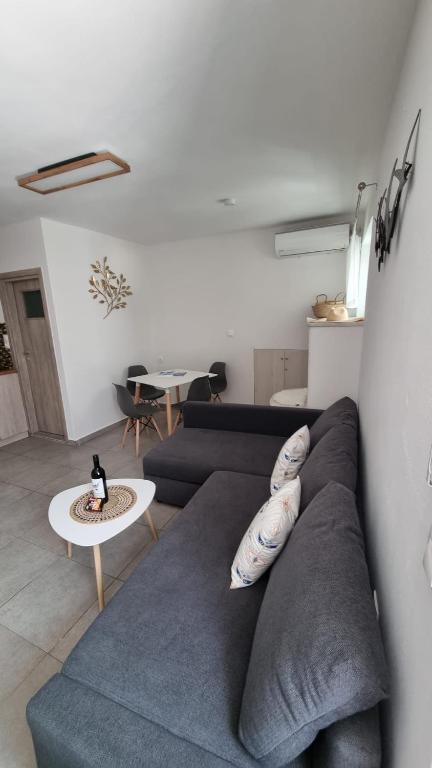 a living room with a blue couch and a table at G-House Skiathos in Skiathos