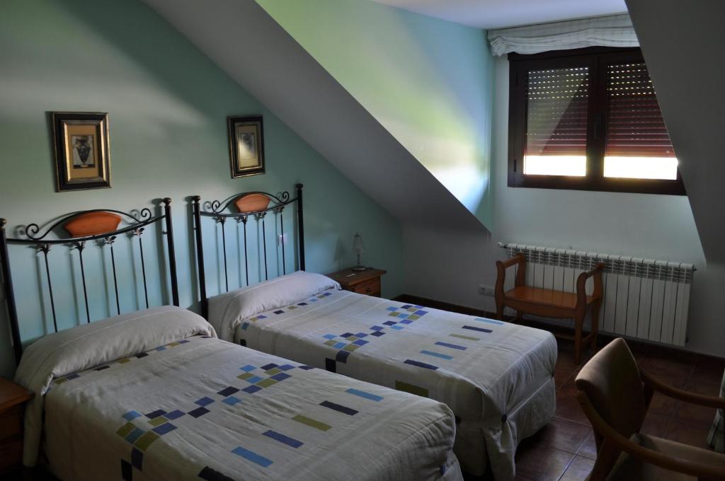 a bedroom with two beds and a staircase at Hotel Puente de Piedra in Zamora
