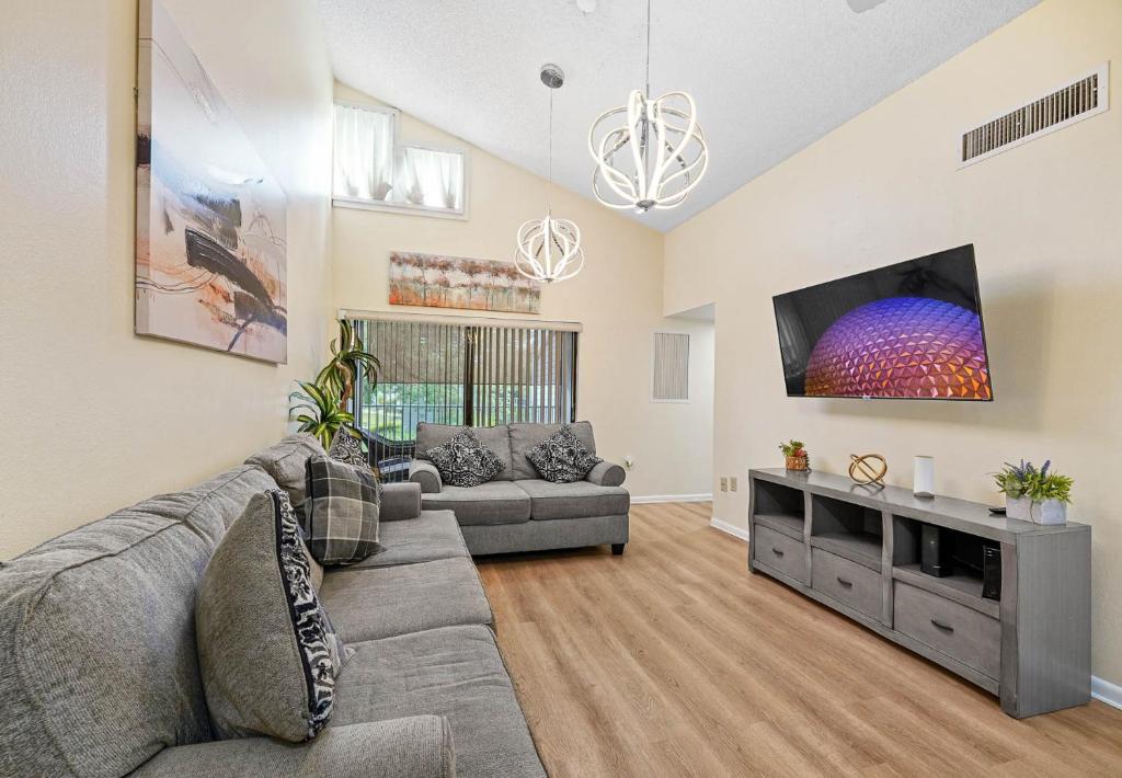 a living room with a couch and a flat screen tv at 3648 Orlando Vacational Apartment in Orlando
