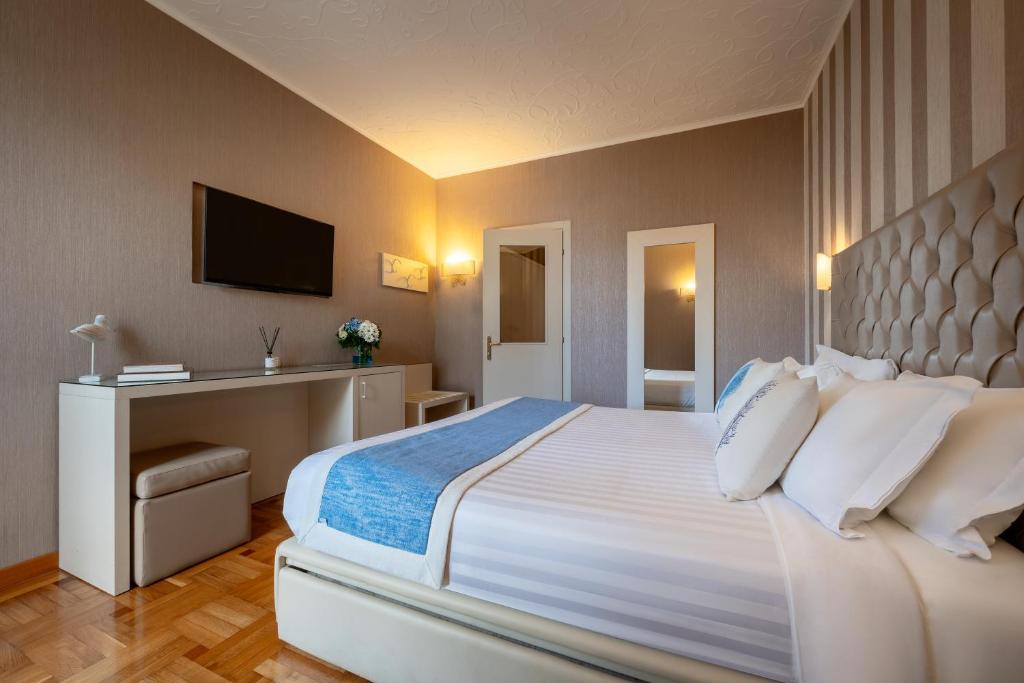 a hotel room with a large white bed and a desk at Hotel Metropole in Santa Margherita Ligure