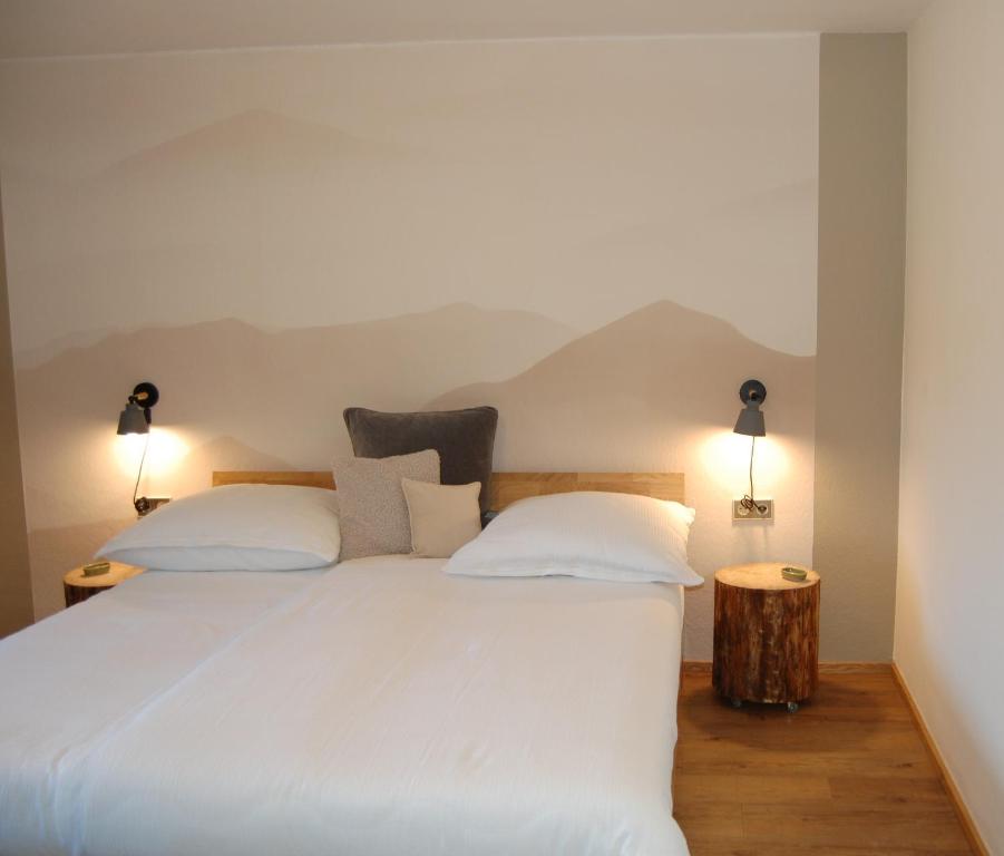 ein Schlafzimmer mit einem weißen Bett und zwei Kissen in der Unterkunft Ferienwohnung mit Balkon I Bergblick I Parkplatz Apartment ONE in Bad Hindelang