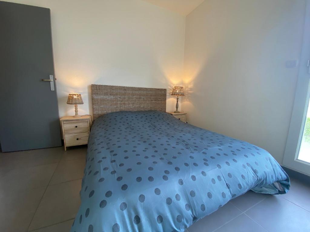 une chambre avec un lit avec une couette bleue dans l'établissement Le grand Logis, à Royan