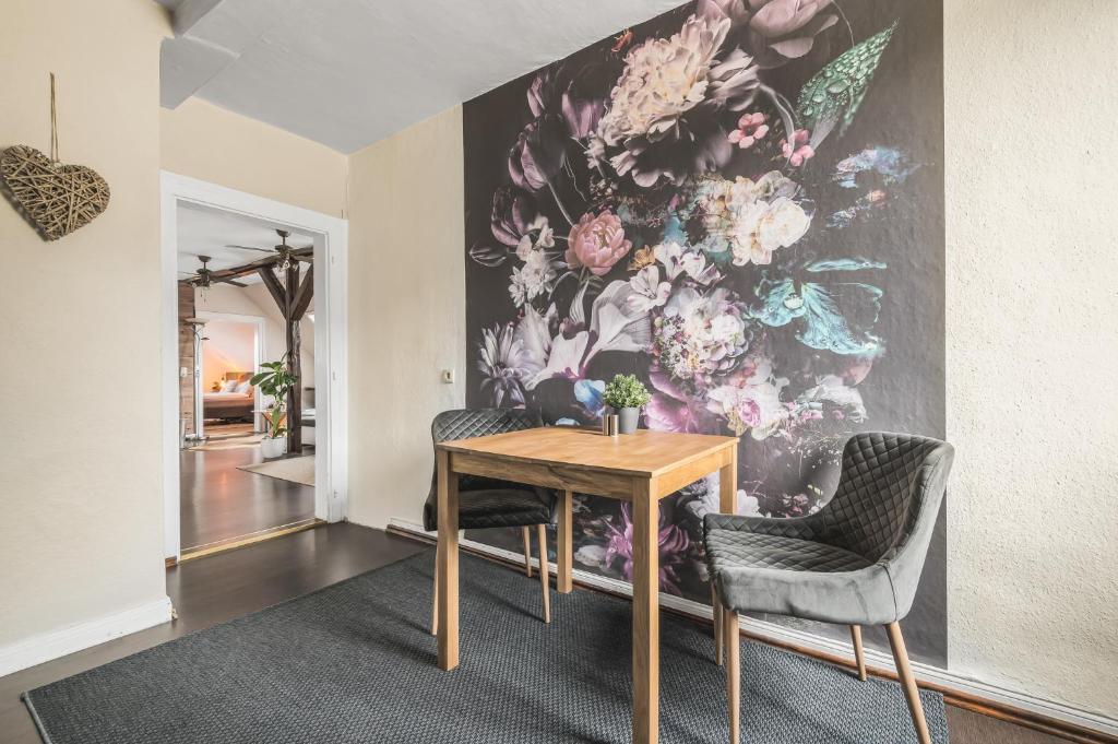 a dining room with a flower mural on the wall at Hirsch-Apartment-5 Eulennest in Bad Harzburg