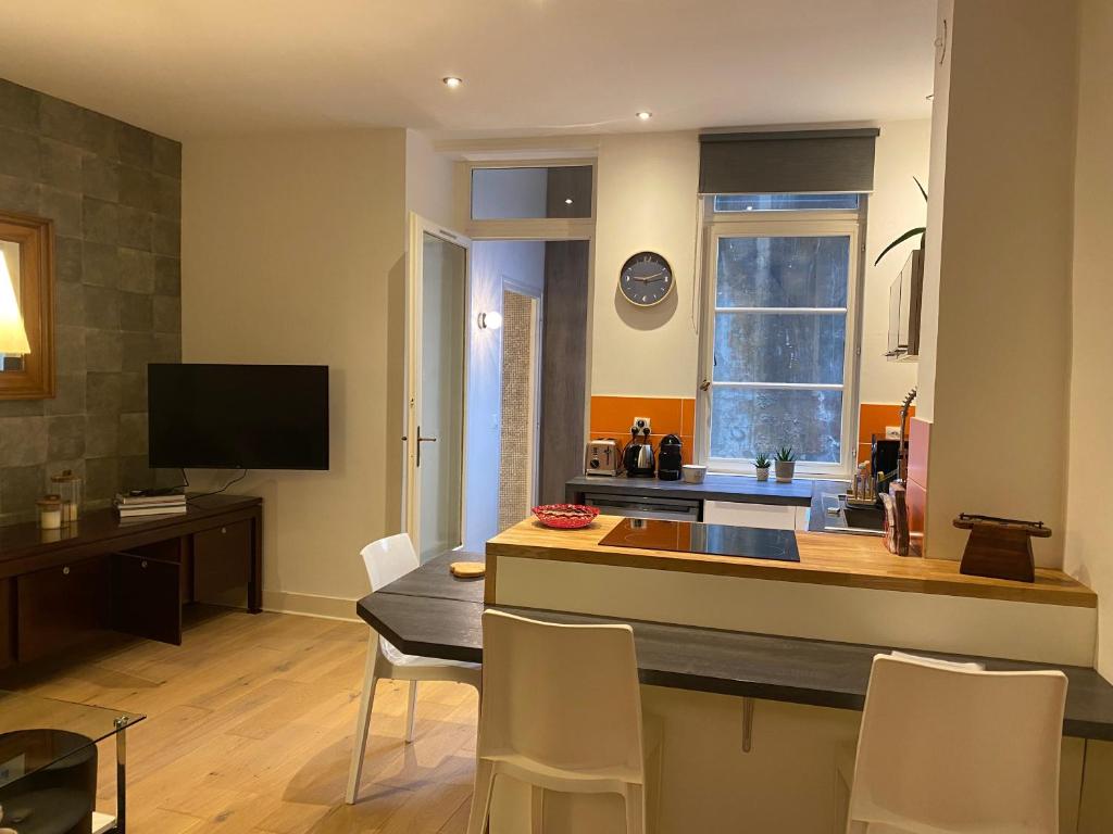 une cuisine avec un îlot de cuisine avec une table et des chaises dans l'établissement Appartement - Bonlieu - Annecy vieille ville, à Annecy