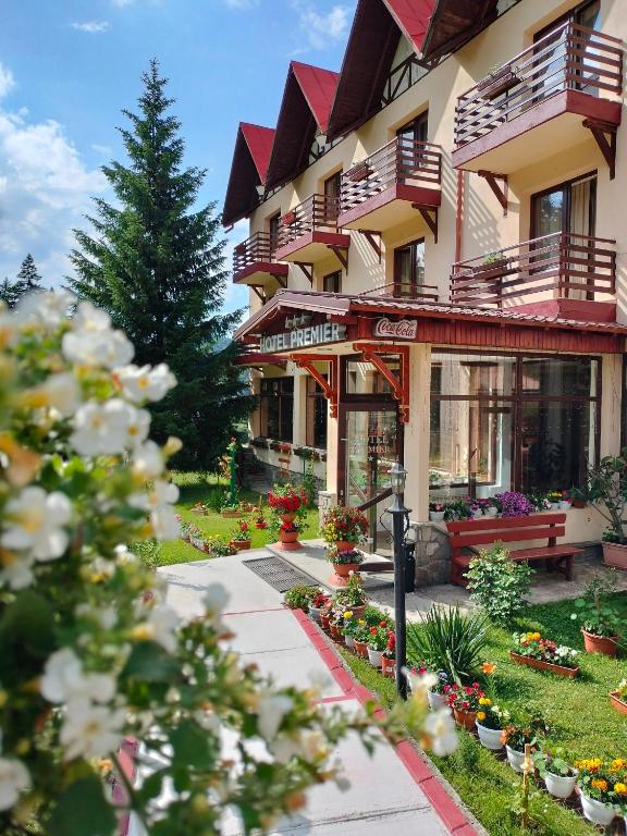 a building with a bench and flowers in front of it at Hotel Premier in Predeal