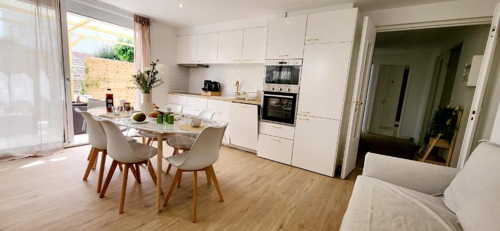 Domino 1 Superbement rénové - 2 chambres - Terrasse à 300m plage commerces في لو غراو دو روا: مطبخ مع طاولة وكراسي في الغرفة