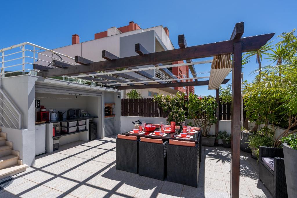 a patio with a table with red dishes on it at Vila Cantinho Algarvio Vista Rio in Ferragudo