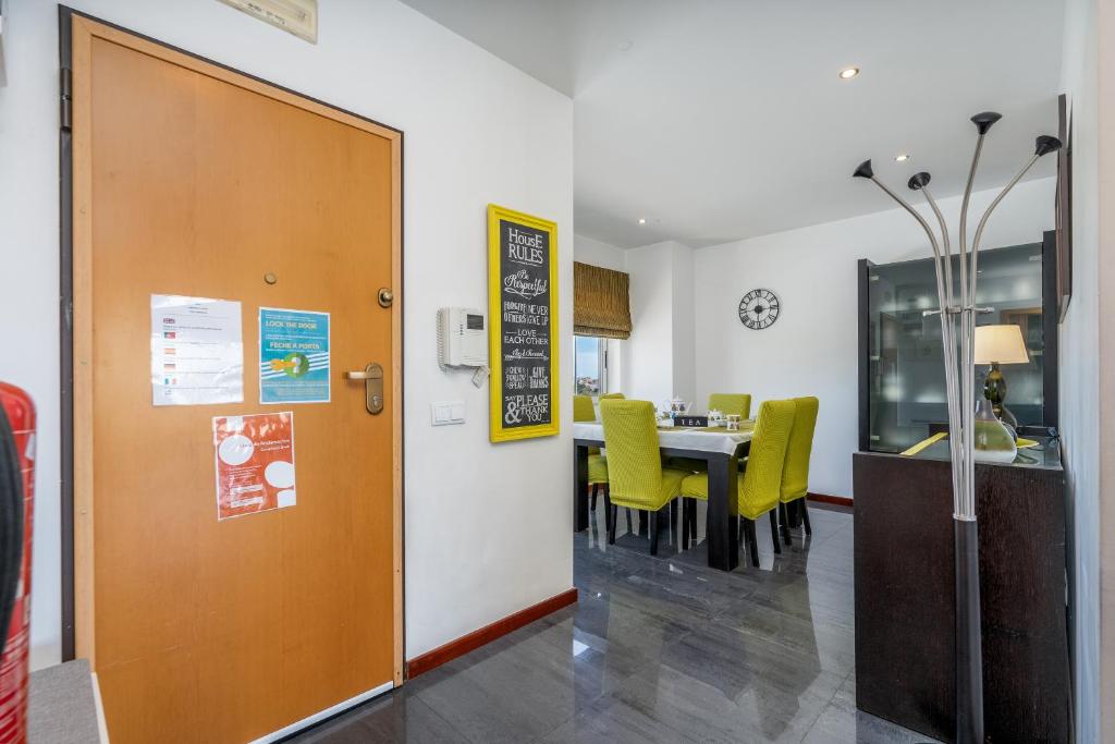 a dining room with a table and yellow chairs at Vila Cantinho Algarvio Vista Rio in Ferragudo