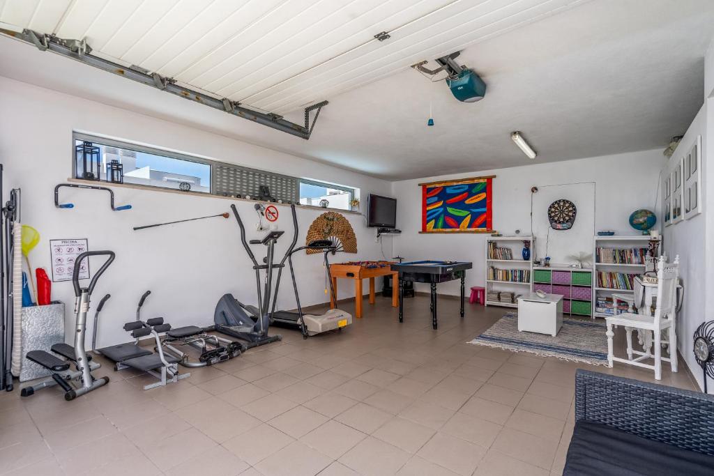a living room with a gym with exercise equipment at Vila Cantinho Algarvio Vista Rio in Ferragudo