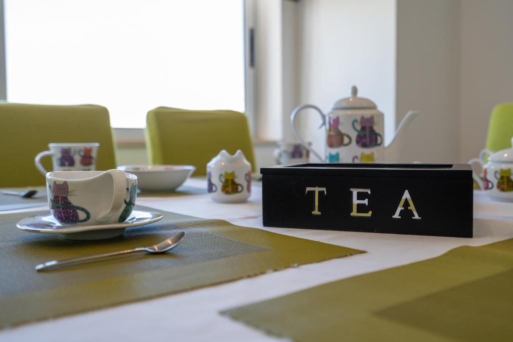 a table with a cup and a tea sign on it at Vila Cantinho Algarvio Vista Rio in Ferragudo
