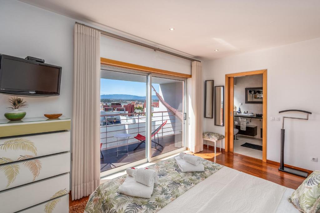 a living room with a large window and a balcony at Vila Cantinho Algarvio Vista Rio in Ferragudo