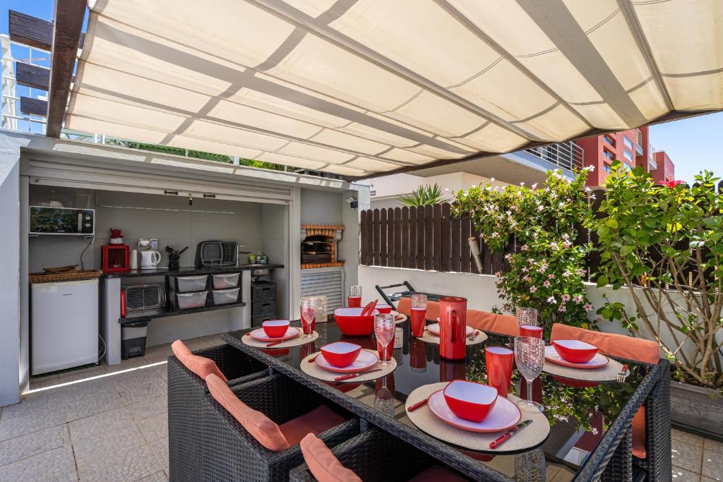a patio with a table and chairs and a kitchen at Vila Cantinho Algarvio Vista Rio in Ferragudo