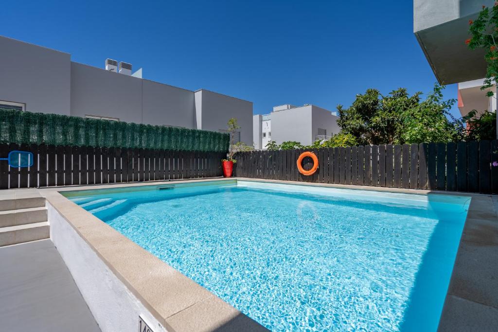 a swimming pool in front of a fence at Vila Cantinho Algarvio Vista Rio in Ferragudo