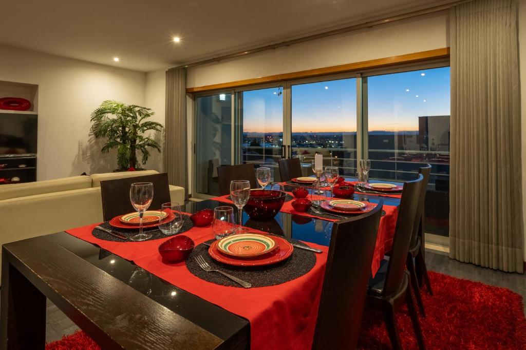 a dining room with a table with a red table cloth at Vila Cantinho Algarvio Vista Rio in Ferragudo