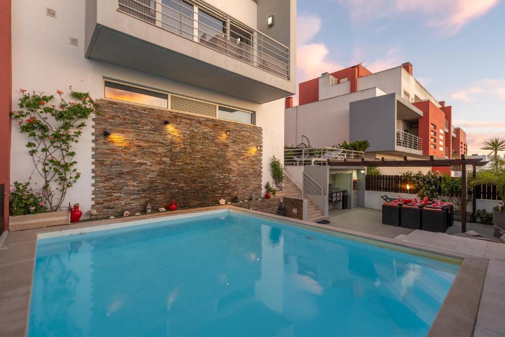 a swimming pool in front of a building at Vila Cantinho Algarvio Vista Rio in Ferragudo