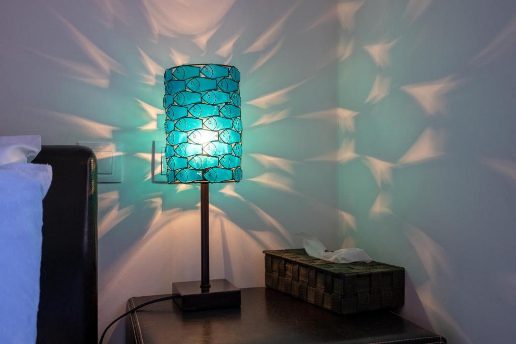 a blue lamp on a table next to a bed at Vila Cantinho Algarvio Vista Rio in Ferragudo