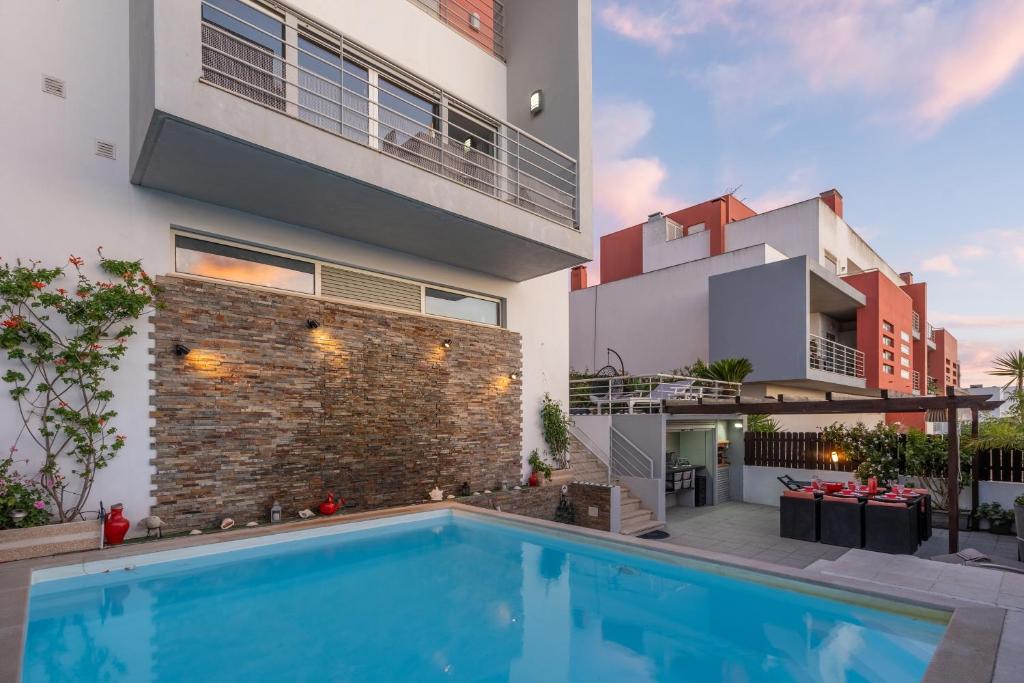 a house with a swimming pool next to a building at Vila Cantinho Algarvio Vista Rio in Ferragudo