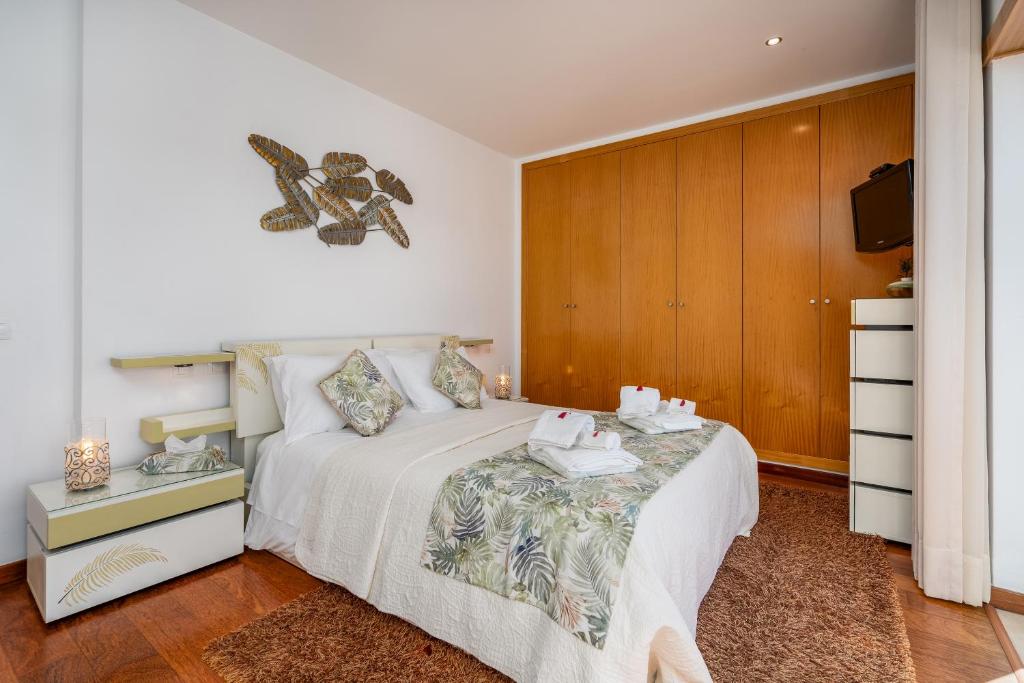 a bedroom with a bed with a dresser and a tv at Vila Cantinho Algarvio Vista Rio in Ferragudo