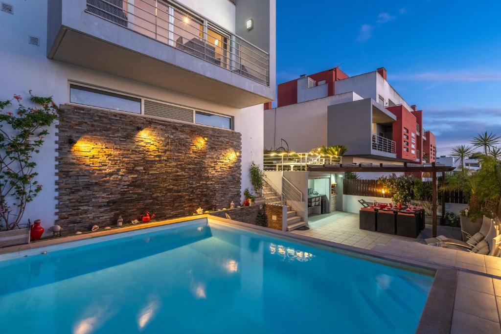 a swimming pool in the backyard of a house at Vila Cantinho Algarvio Vista Rio in Ferragudo