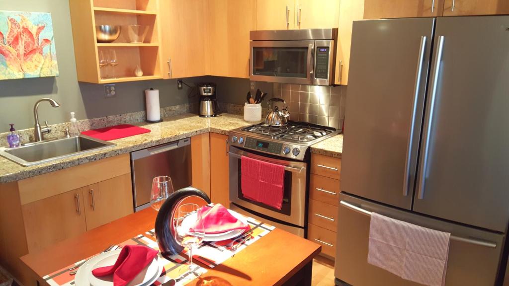 a kitchen with a stainless steel refrigerator and a table at Orenco Lofts in Hillsboro