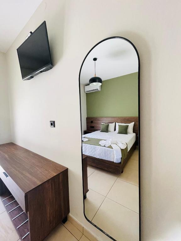 a bedroom with a bed and a mirror at Lafo Rooms in Elafonisi