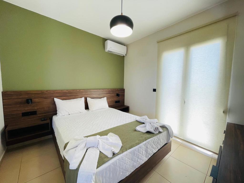 a bedroom with a bed with white sheets and a window at Lafo Rooms in Elafonisi