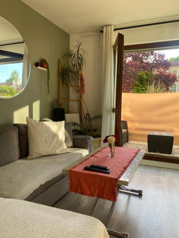 un salon avec un canapé et une table dans l'établissement Cocon charmant et fonctionnel, à Le Port-Marly