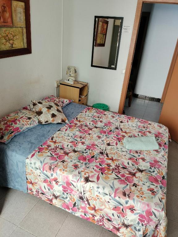 a bed with a floral comforter in a bedroom at KALIFORNIA CENTRAL in Alicante