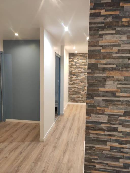 une pièce vide avec un mur en briques et un couloir dans l'établissement Appartement Cosy, 3 Chambres près du centre ville, à Orvault