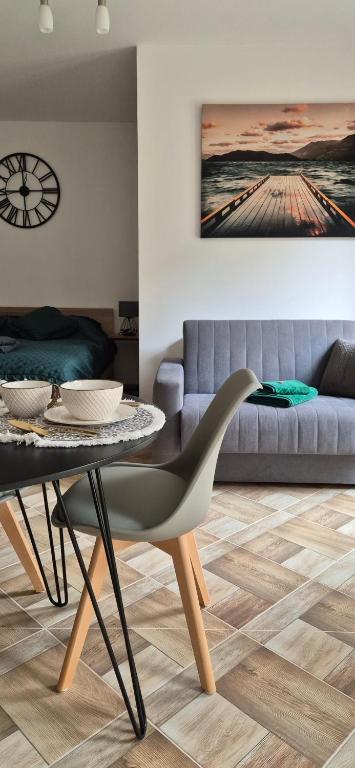 a living room with a table and a couch at Karmelowy Zakątek in Darłowo