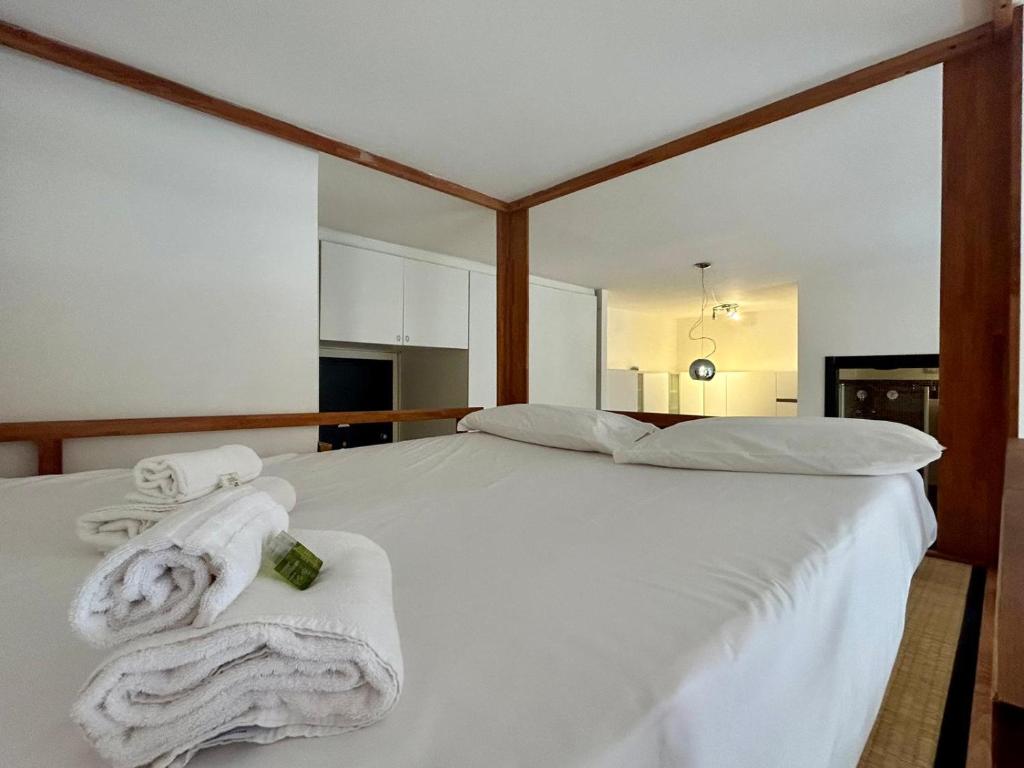 ein Schlafzimmer mit einem weißen Bett mit Handtüchern darauf in der Unterkunft Kibilù - Via Morosini - Policlinico - Centro Città in Mailand