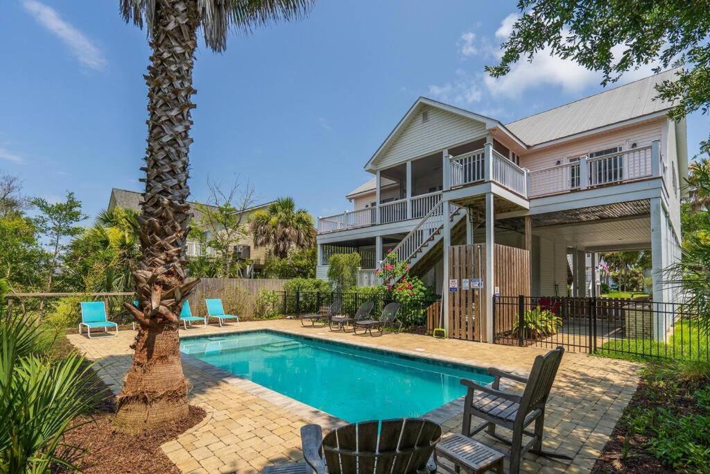 a house with a swimming pool and a palm tree at Pompano Pool House in Edisto Island