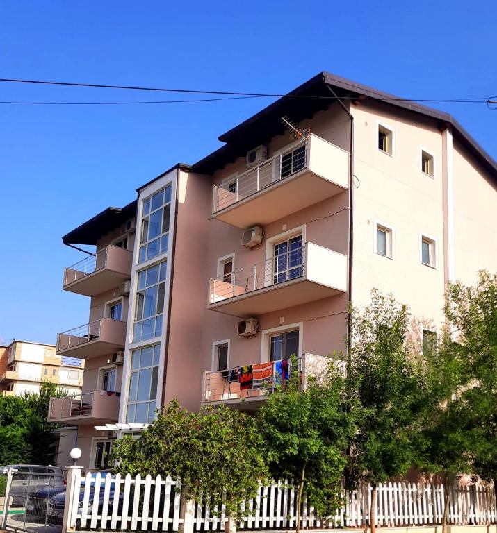 a tall apartment building with people on a balcony at Apartments Alavana in Velipojë