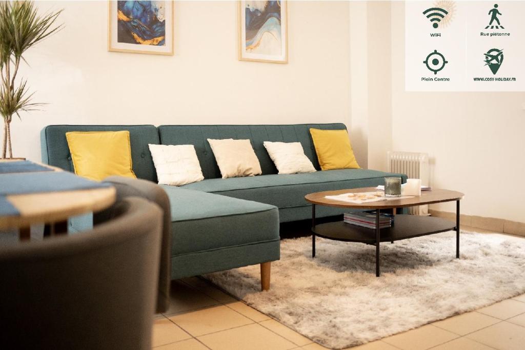 un salon avec un canapé bleu et une table dans l'établissement COSY TRIPLEX PLEIN CENTRE maison de ville, à Boulogne-sur-Mer