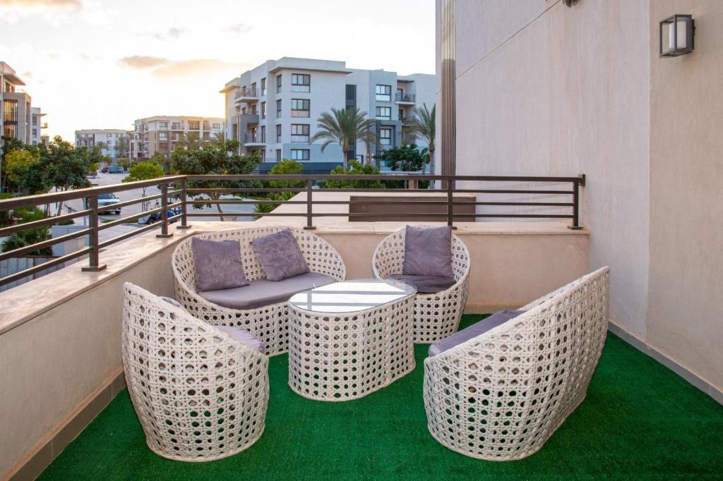 d'un balcon avec des chaises en osier et une table. dans l'établissement Marina marassi, à Sīdī ‘Abd ar Raḩmān