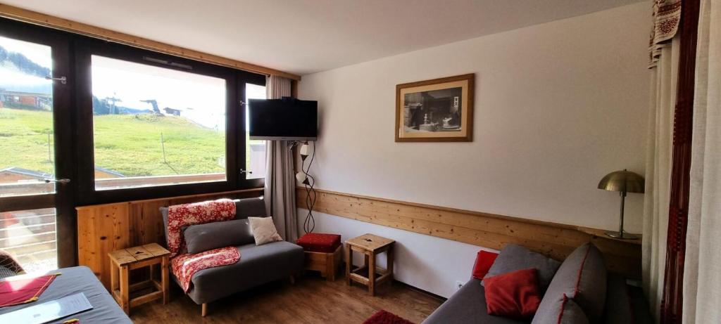 - un salon avec un canapé, une chaise et une fenêtre dans l'établissement Résidence Diamant - Studio pour 4 Personnes 204, à La Plagne Tarentaise