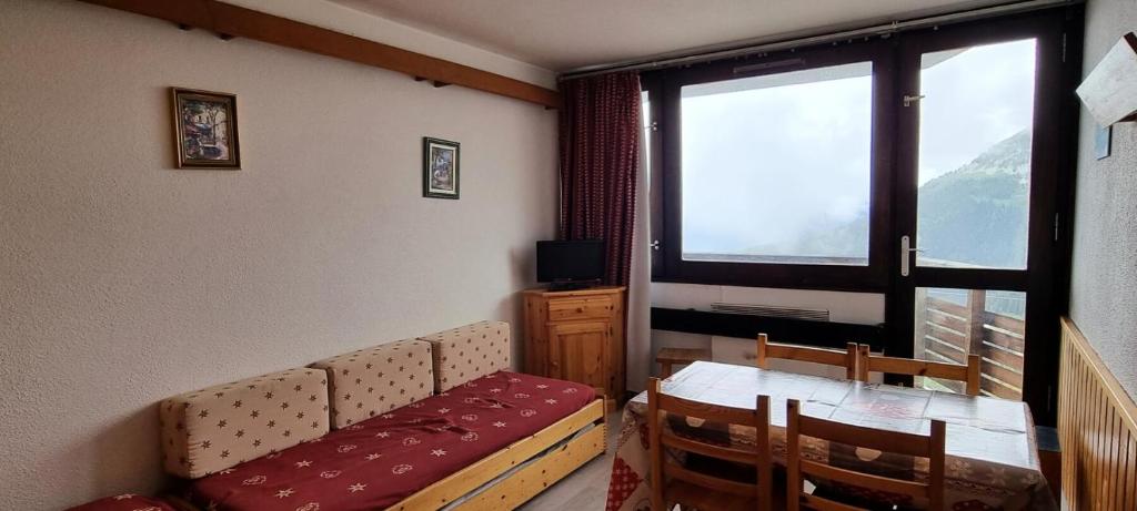 un salon avec un canapé, une table et une fenêtre dans l'établissement Résidence Etoile - Studio pour 4 Personnes 334, à La Plagne Tarentaise
