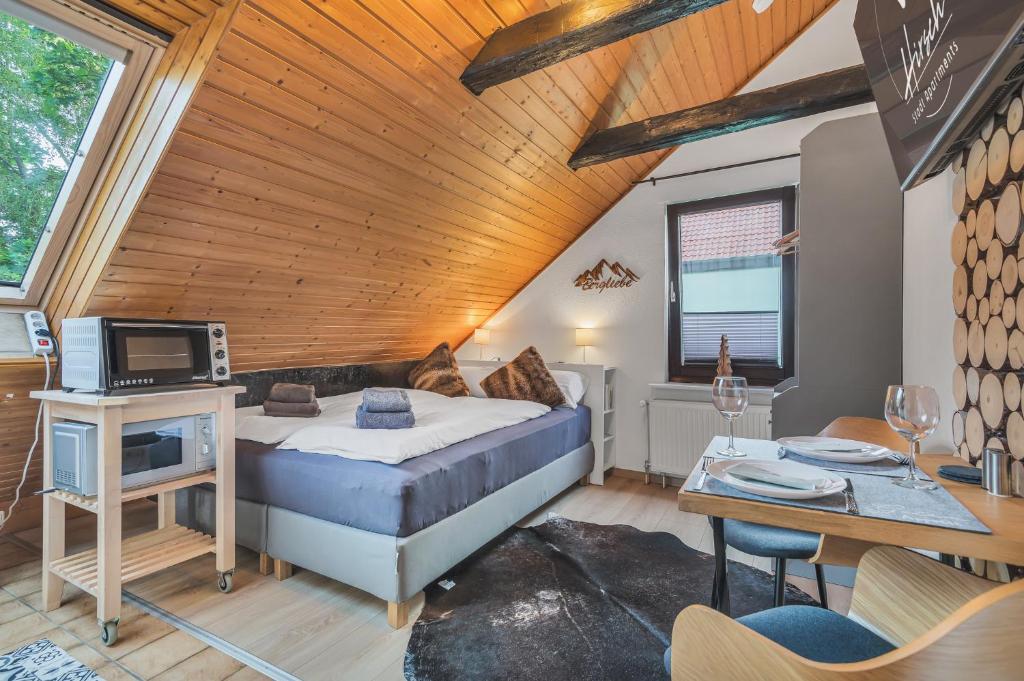 Un dormitorio con una cama, un televisor y una mesa. en HIRSCH Stadt Apartment 5 - Parkplatz - Zentral, en Bad Harzburg