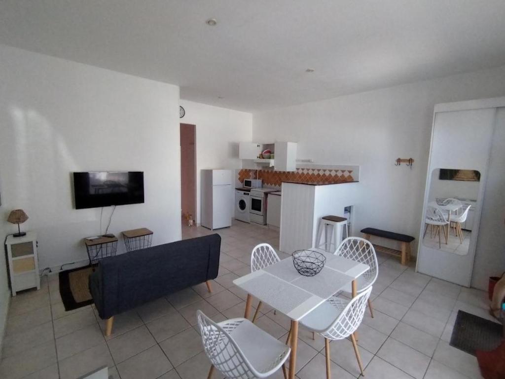 un salon avec une table et des chaises et une cuisine dans l'établissement T2 proche chatelaillon plage, à Salles-sur-Mer