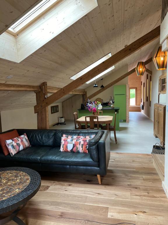 un salon avec un canapé en cuir et une table dans l'établissement Le gîte Samezo, à Villers-le-Lac