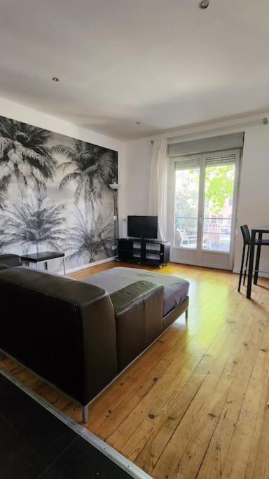 une chambre avec un grand lit avec un plancher en bois dans l'établissement T3 Petit Confort - proche commodités - Parking privé, à Toulouse