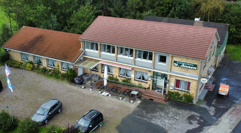 an aerial view of a house with cars parked in a parking lot at Landgasthaus Sankt Annen in Sankt Annen