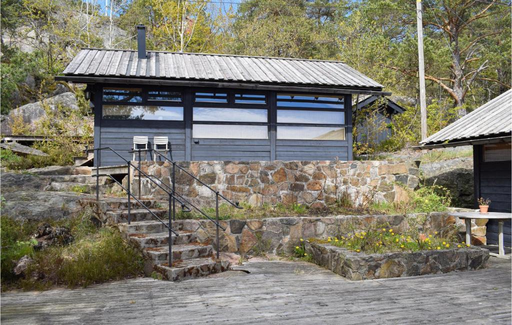a small building with a stone wall and stairs in front at Four-Bedroom Holiday Home In Tvedestrand in Tvedestrand