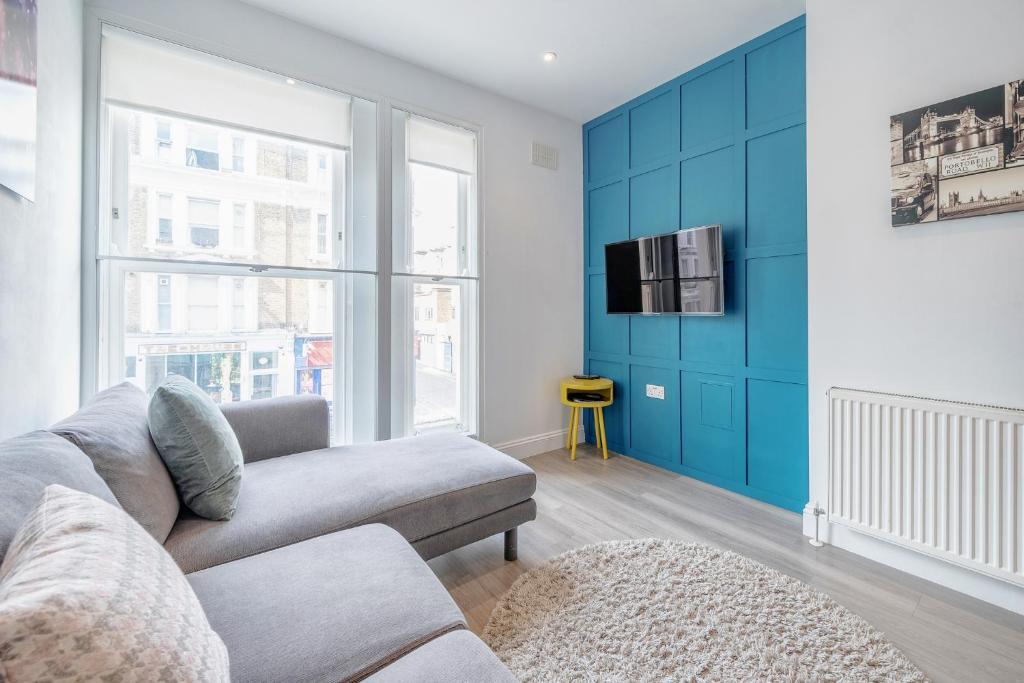 Hotel 2-bed Notting Hill / Portobello, a living room with a couch and a tv at 2-bed Notting Hill / Portobello in London