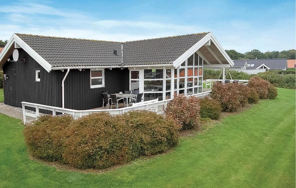 a black house with a porch and a white fence at Holiday Home Hvedemarken Vi in Hejls
